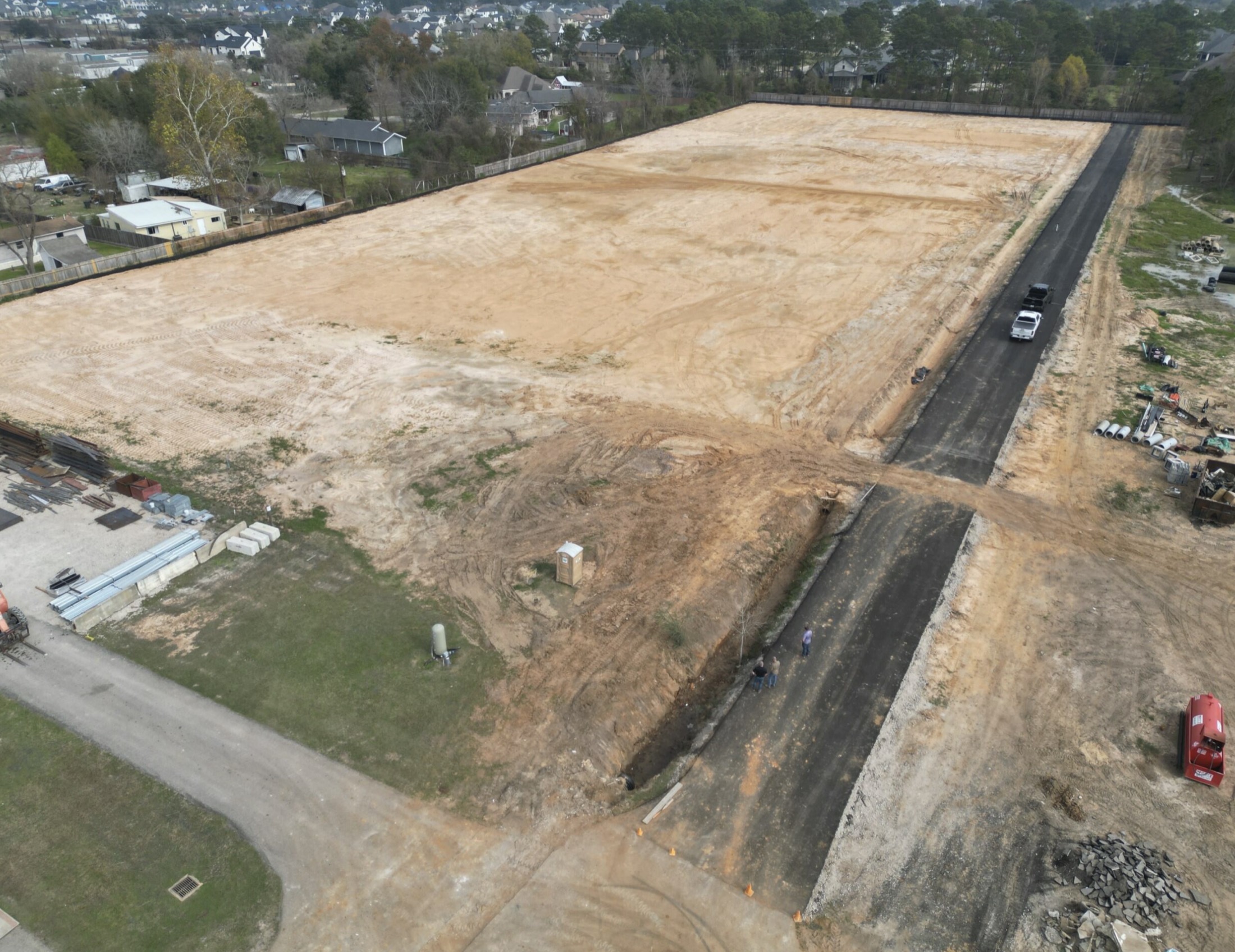 Cleared commercial site with access road and graded pad